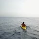 Flying above a young man kayaking on the sea - VideoHive Item for Sale