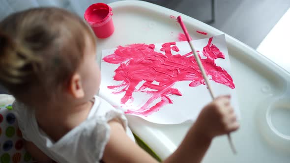 Cute Little Girl Painting with Brushes at Home