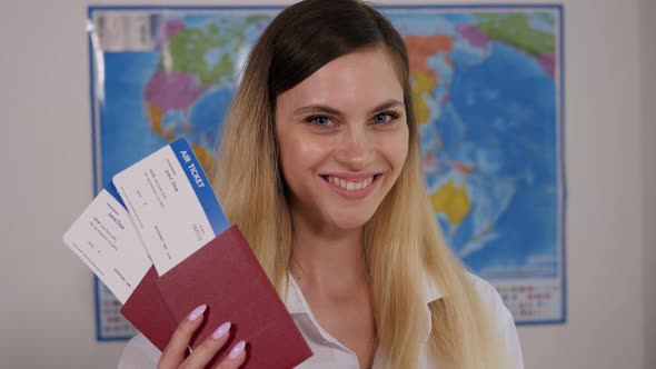 Closeup of the Face of a Young Happy Woman with Passports and Tickets