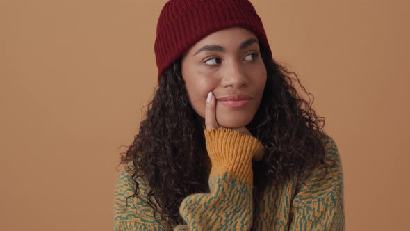 Pensive African curly-haired woman looking to the sides and agree with something