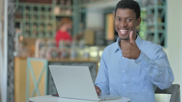 Thumbs Up By Young African Man Working in Cafe 