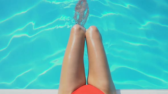 Close Up of Womans Legs Playing With Water in Swimming Pool, Pure Blue Water