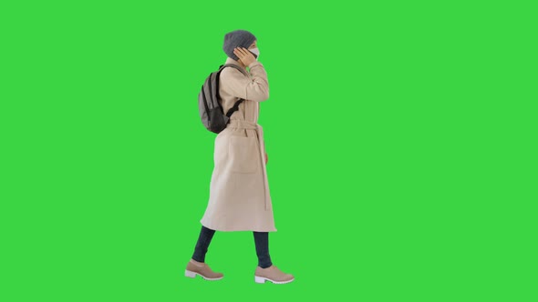 Woman Wearing Medical Mask Walking and Calling Someone One the Phone on a Green Screen, Chroma Key.