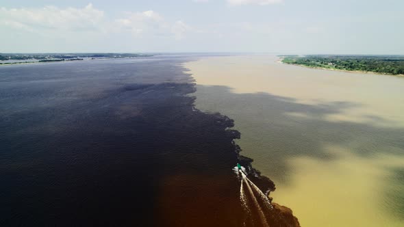 The Boat Sails on the Border of Two Rivers of the Amazon