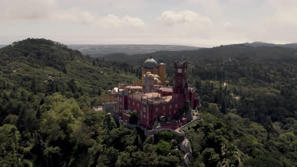 Fairy tale hilltop Pena Palace, Romanticist castle in Sintra, Portugal. Orbiting shot