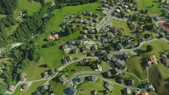 Flying over alpine houses in green valley, grindelwald Switzerland