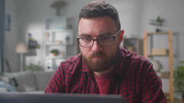 Bearded Man Using Computer for Remote Work at Home