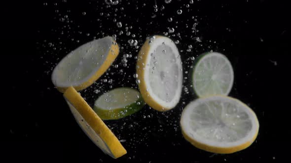 Lemon Slices Falling into Water Super Slowmotion, Black Background, lots of Air Bubbles, 4k240fps