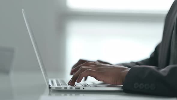 Close up of Hands of African Businessman Working on Laptop