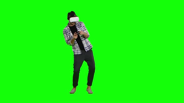 Surprised Man Uses Virtual Reality Goggles Play with Joystick. Green Screen