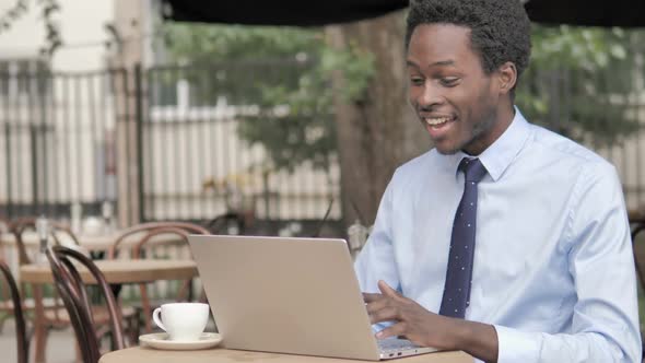 African Businessman with Neck Pain Using Laptop Outdoor