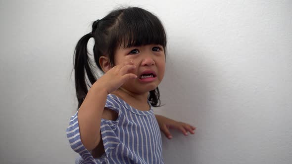 A Litter Asian girl sitting in room conner and crying after Punished by the blackout.