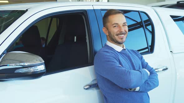 A Happy Man Is Leaning on His New Car