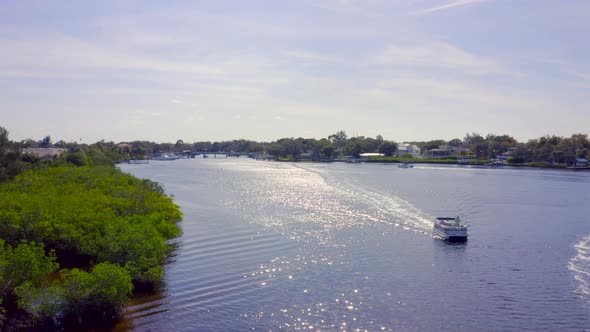 Flying Over Boat on Bay and Towards Waterfront Houses in New Port Richey Florida