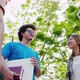 Lower angle shot of Asian student friends talking in park in college. - VideoHive Item for Sale