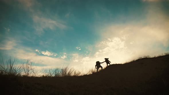 Couple Hiking Help Each Other Silhouette in Mountains. Teamwork Couple Hiking, Help Each Other