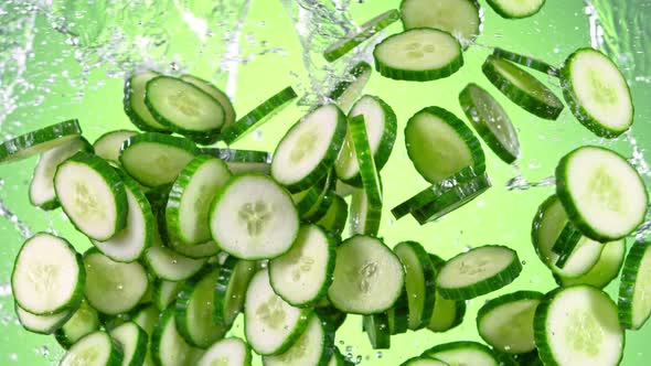 Super Slow Motion Shot of Flying Fresh Cucumber Slices and Water Side Splash at 1000 Fps