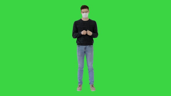 Coronavirus Man Wearing Protective Mask Cleaning His Hands with Sanitizer on a Green Screen, Chroma