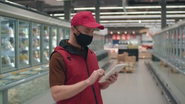 Merchandiser Working On Tablet In Supermarket