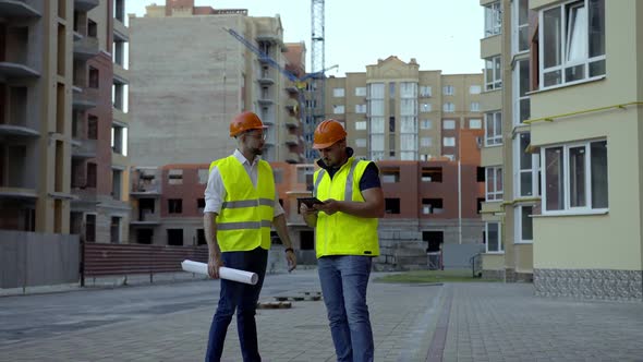 Meeting of Two Workers on Their Work Orange Helmets