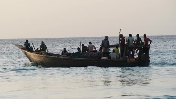 African Wooden Fishing Boat with Fishermen Sailing in Ocean Zanzibar Tanzania