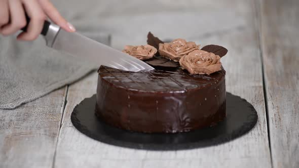 Woman Cutting a Delicious Chocolate Prague Cake