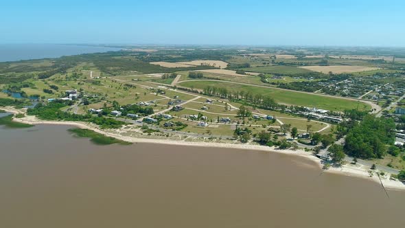 Aerial scene with beach drones. The camera zooms in towards the coast. Colonia de Sacramento, Urugua