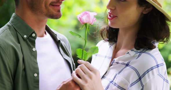 Romantic couple smelling rose in garden