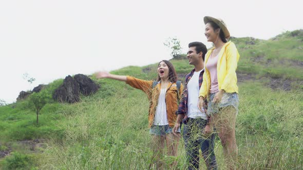 Happy group of friends walking in countryside in summer.