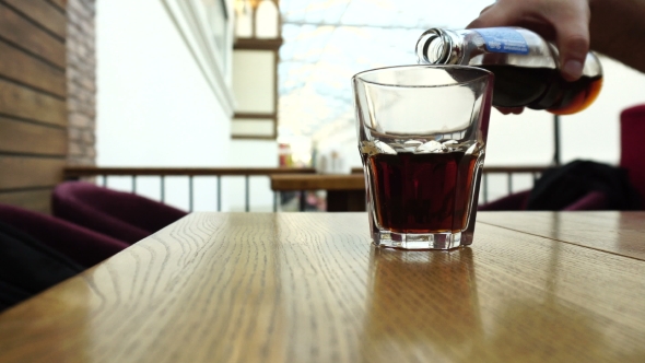 Pouring Cola From The Bottle Into a Glass