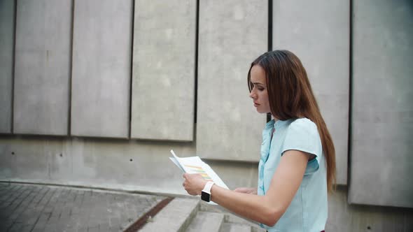 Businesswoman Examining Financial Statistics Outdoors. Woman Going for Work