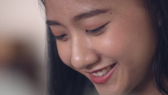 Close-up portrait of attractive Asian woman smiling happy enjoying summer.