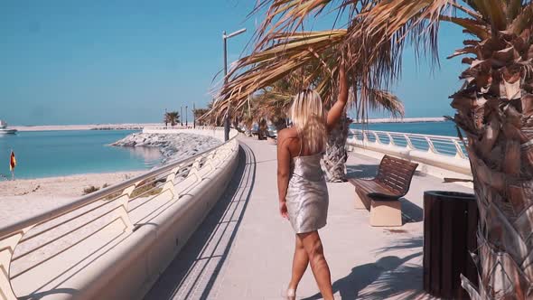 A Girl Walking Along the Beach in Dubai in a Dress