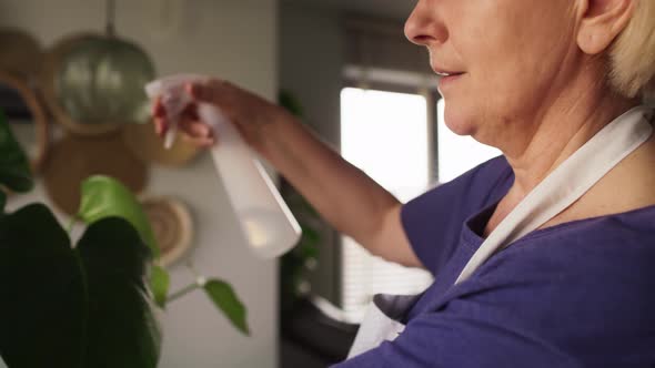 Video of senior woman taking care about plants at her house. Shot with RED helium camera in 8K.