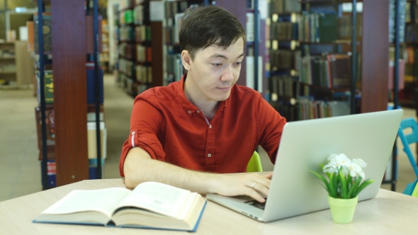 Male Student Working With Laptop In The City Library