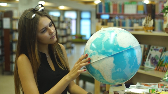 Female College Student Looking At a Globe