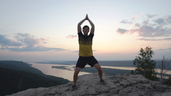 Young Man Doing Jumps On Top Of a Mountain