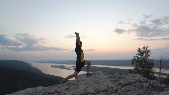 Young Man Doing Exercise To Stretch The Top Of The Mountain