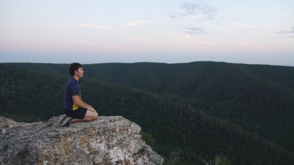 Man Sitting On The Top Of The Mountain In Meditation Session