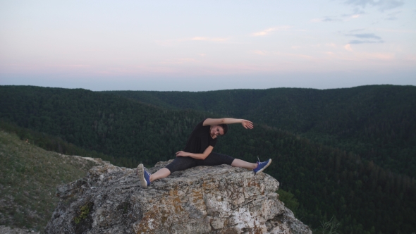 Young Woman Doing Exercises For Stretching On Top Of a Mountain