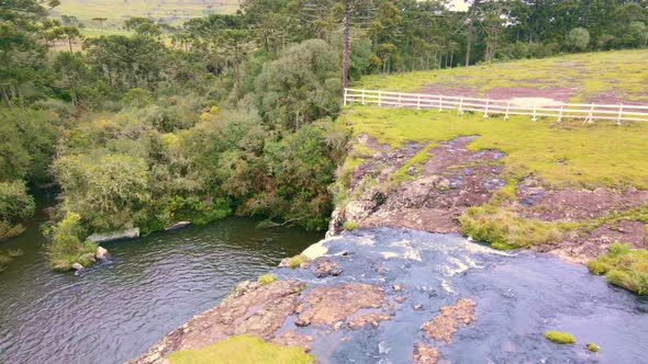 Waterfall in Rural area with Mossy Rocks and lots of Green and Trees. Aerial Drone Footage.