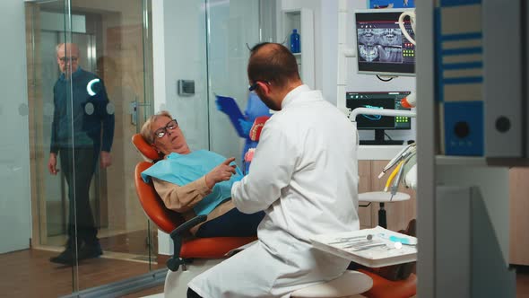 Dentist Explaining the Surgery Using a Plaster Model of the Mandible