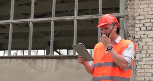 Worker With a Walkie-talkie at a Construction Site