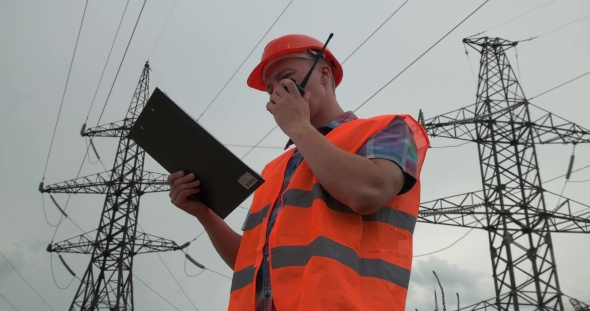 Worker With a Walkie-talkie at a Power Plant