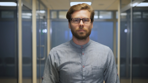 Young Bearded Businessman Rearranges Glasses