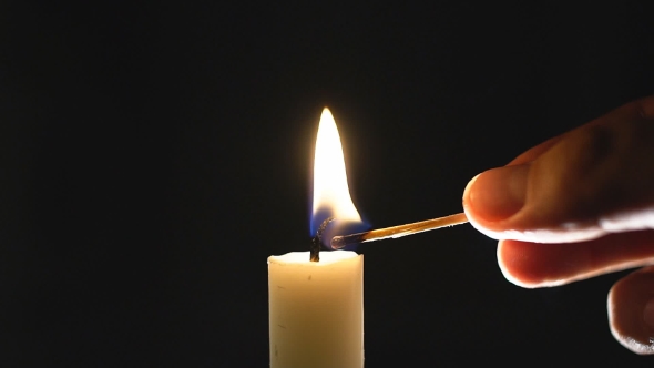 Male Hand  Lights A Candle.