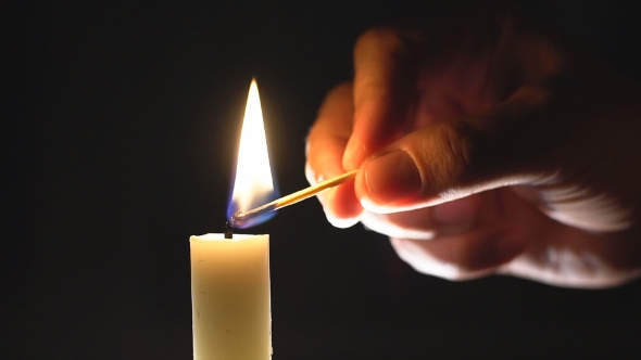 Male Hand  Lights A Candle.