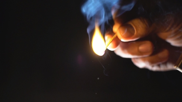 Male Hand  Lights A Match.