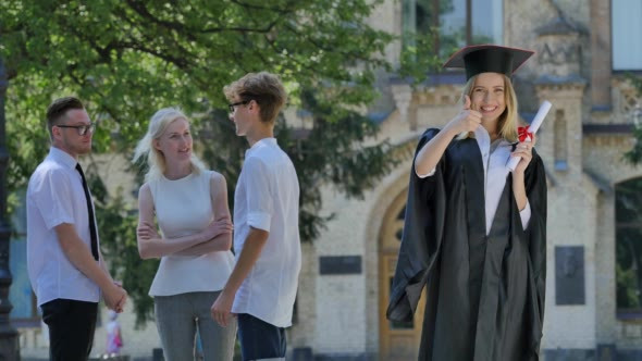 Graduand Woman in Mantle Holding Diploma Smiling