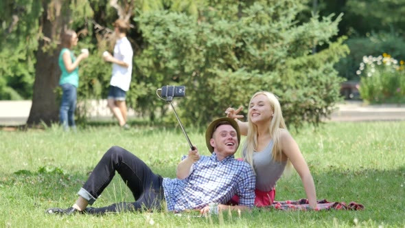 Teenagers on a Picnic on a Lawn Taking Photos